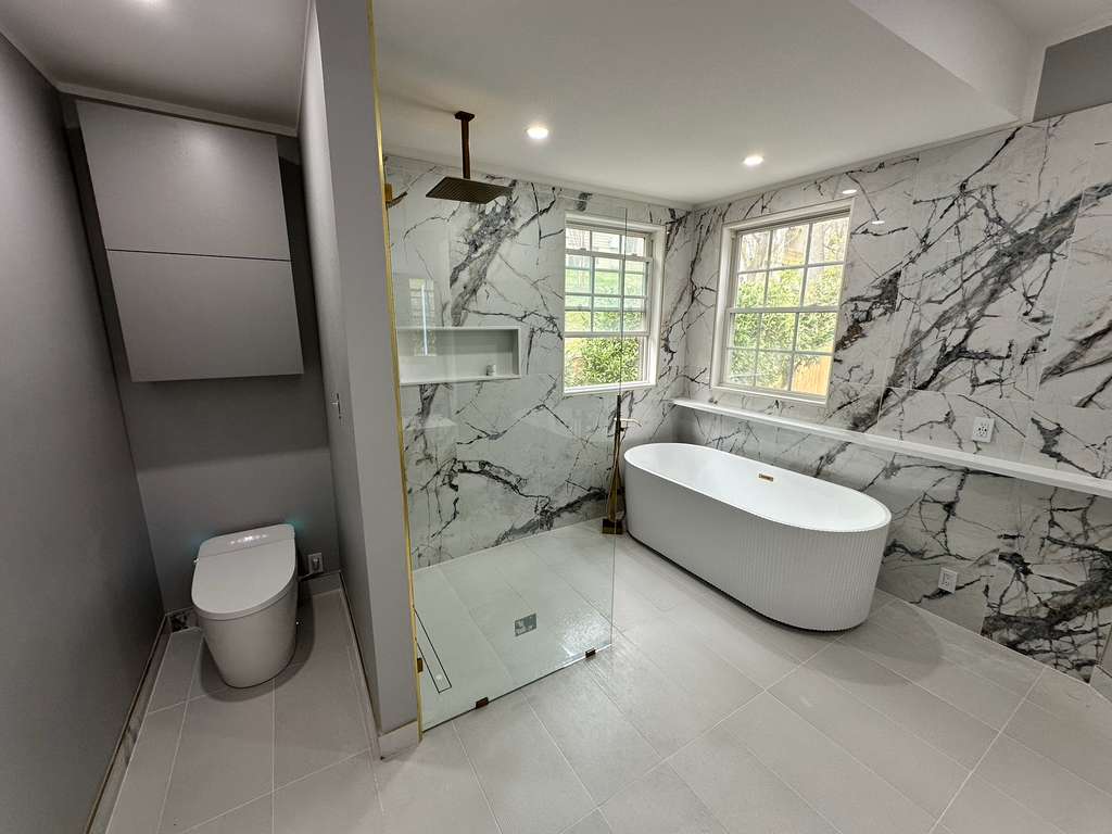 After: Dated corner tub to a marble wet-room