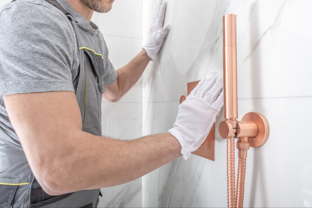 A man installing acrylic shower bases and a tub surround. 