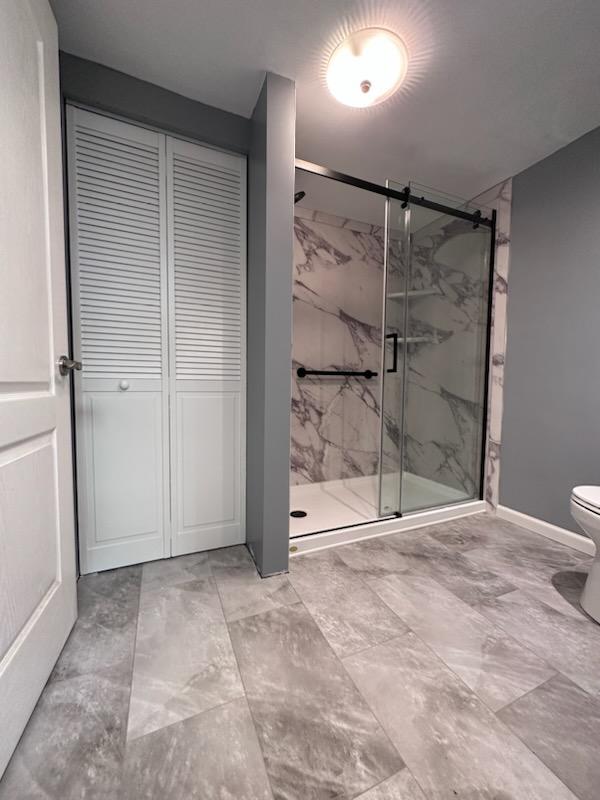A completed bathroom conversions project that includes a brand new walk-in shower, closet, and tiled flooring. 