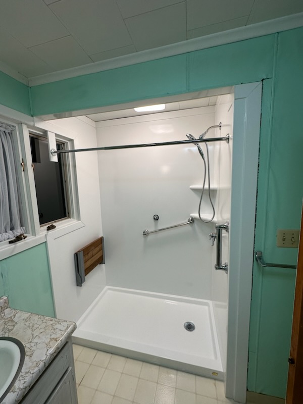 A new walk-in shower replaced an old bathtub in this bathroom conversions project from Just Bath. 