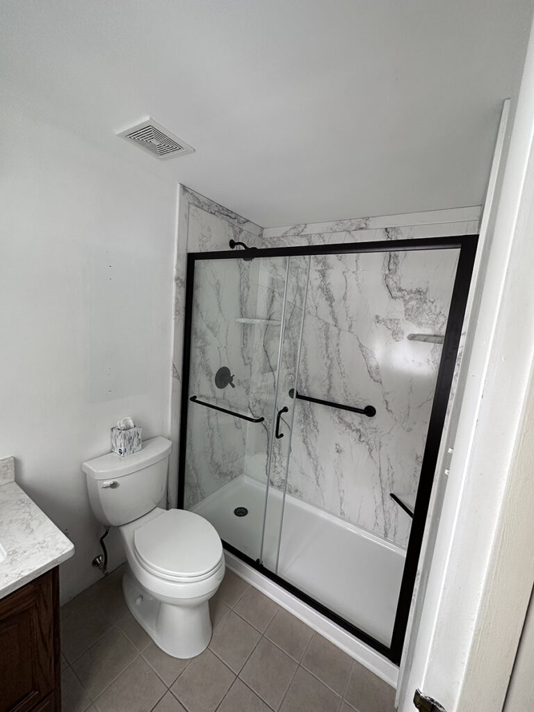 A completed bathroom conversions project that turned an old bathtub into a new walk-in shower. 