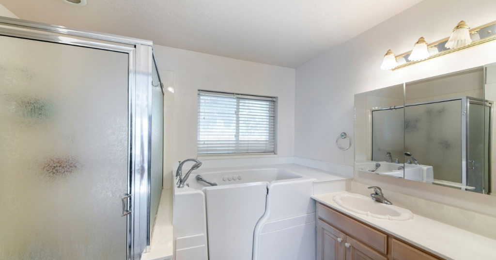 A walk-in bathtub appears next to a walk-in shower and a bathroom sink in an accessible bathroom conversions project. 